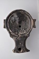 Diskuslampe mit geradem Schnauzenabschluss (Dressel Typ III) mit Schnauzenkanal und Seiten-/"Ohren-"henkeln ("schwalbenschwanzförmige Handhaben"): Mänaden- oder Dionysoskopf; Efeuranke